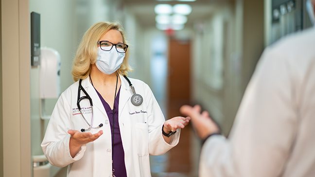 Dr. Ecaterina Dumbrava stands in a hallway