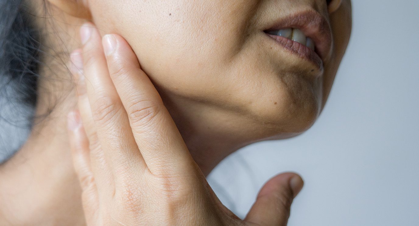 Woman touching her neck in pain