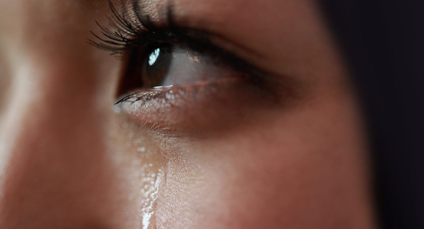 Image of a woman with a tear rolling down her cheek