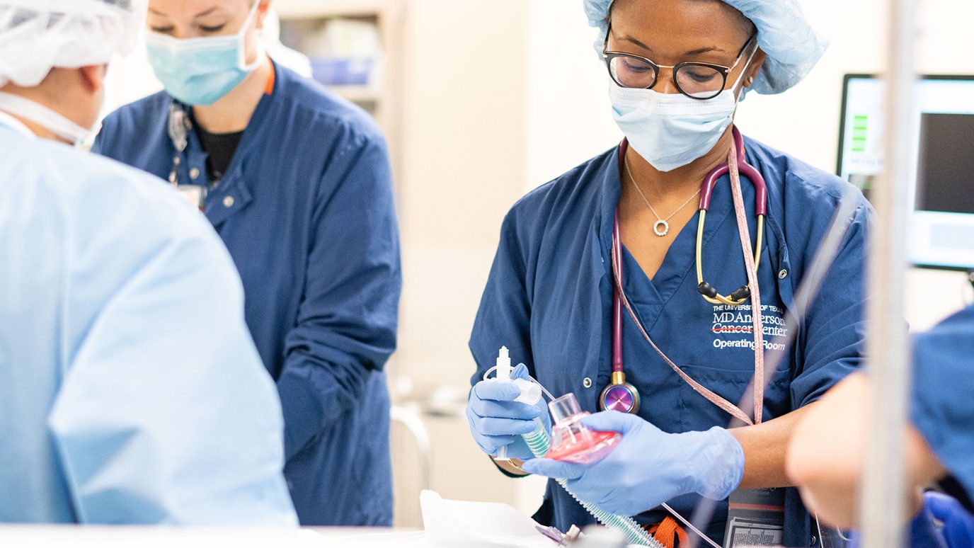 Anesthesiologist Techecia Idowu, M.D. prepares an oxygen mask before a procedure in the operating room with nurse Holly Vinson.