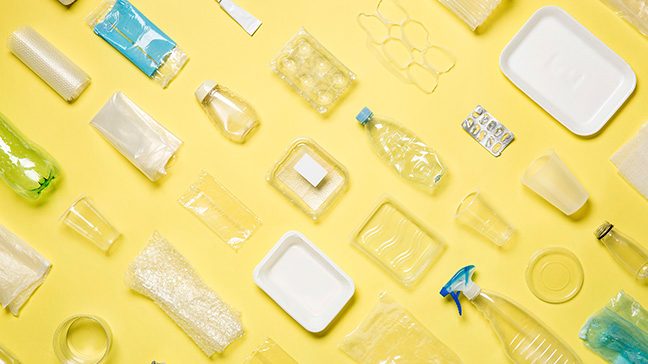 Different types of used plastic packaging arranged on a yellow background