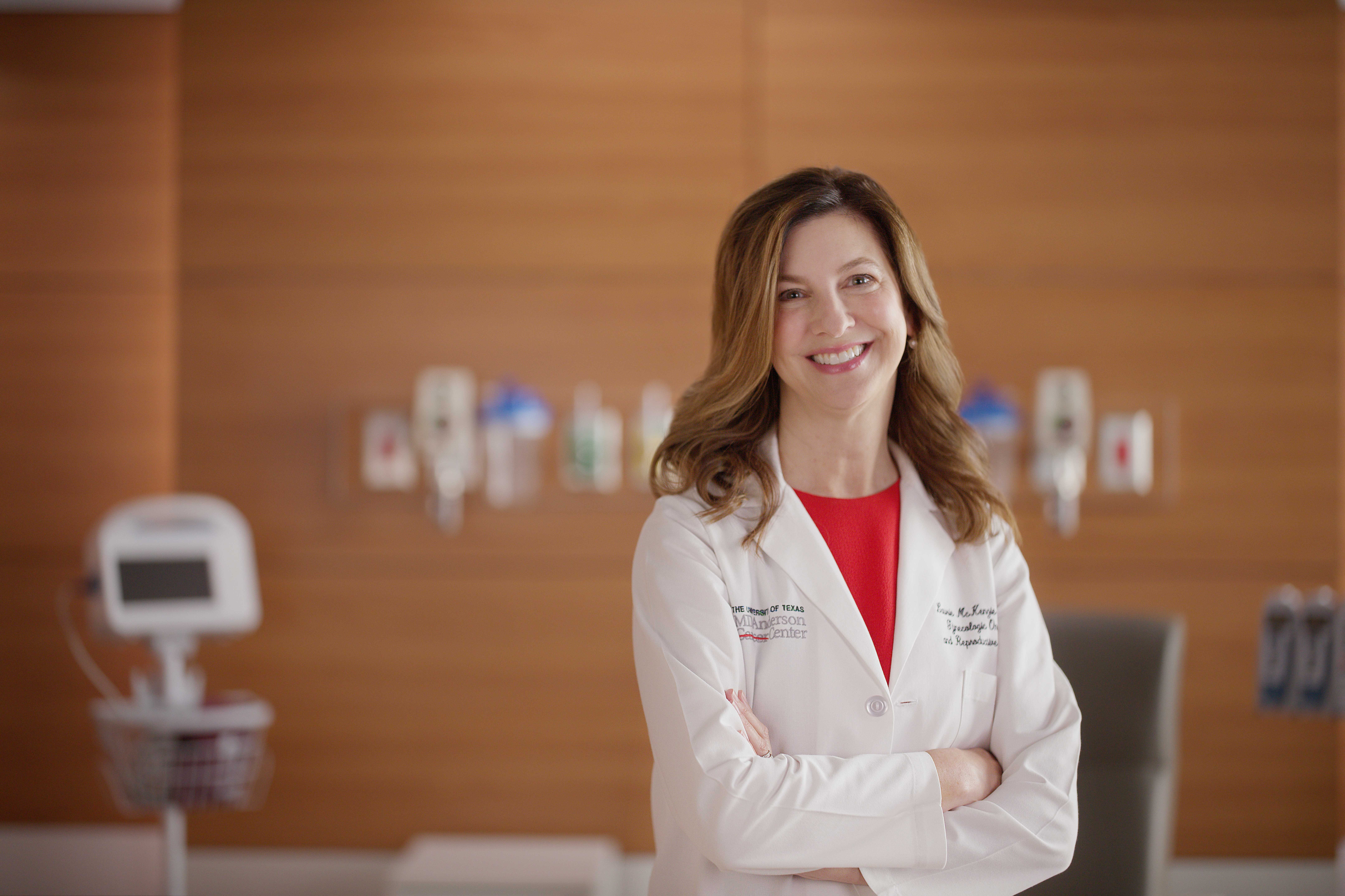 Dr. Laurie McKenzie stands with her arms crossed in white lab coat