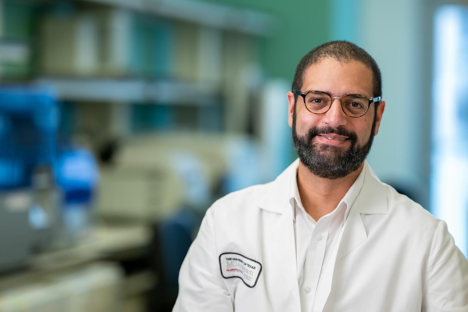 Man with facial hair wearing glass and a white lab coat