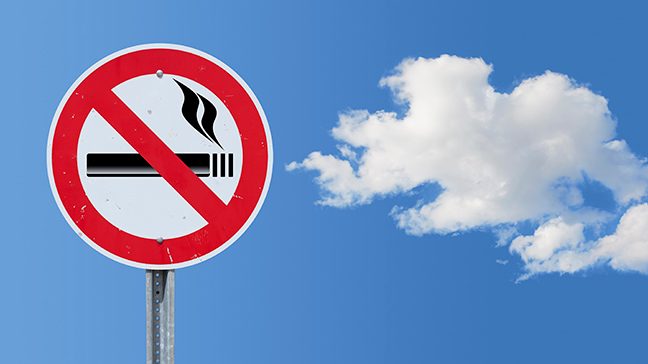 No smoking sign with cleverly positioned cloud in blue sky background