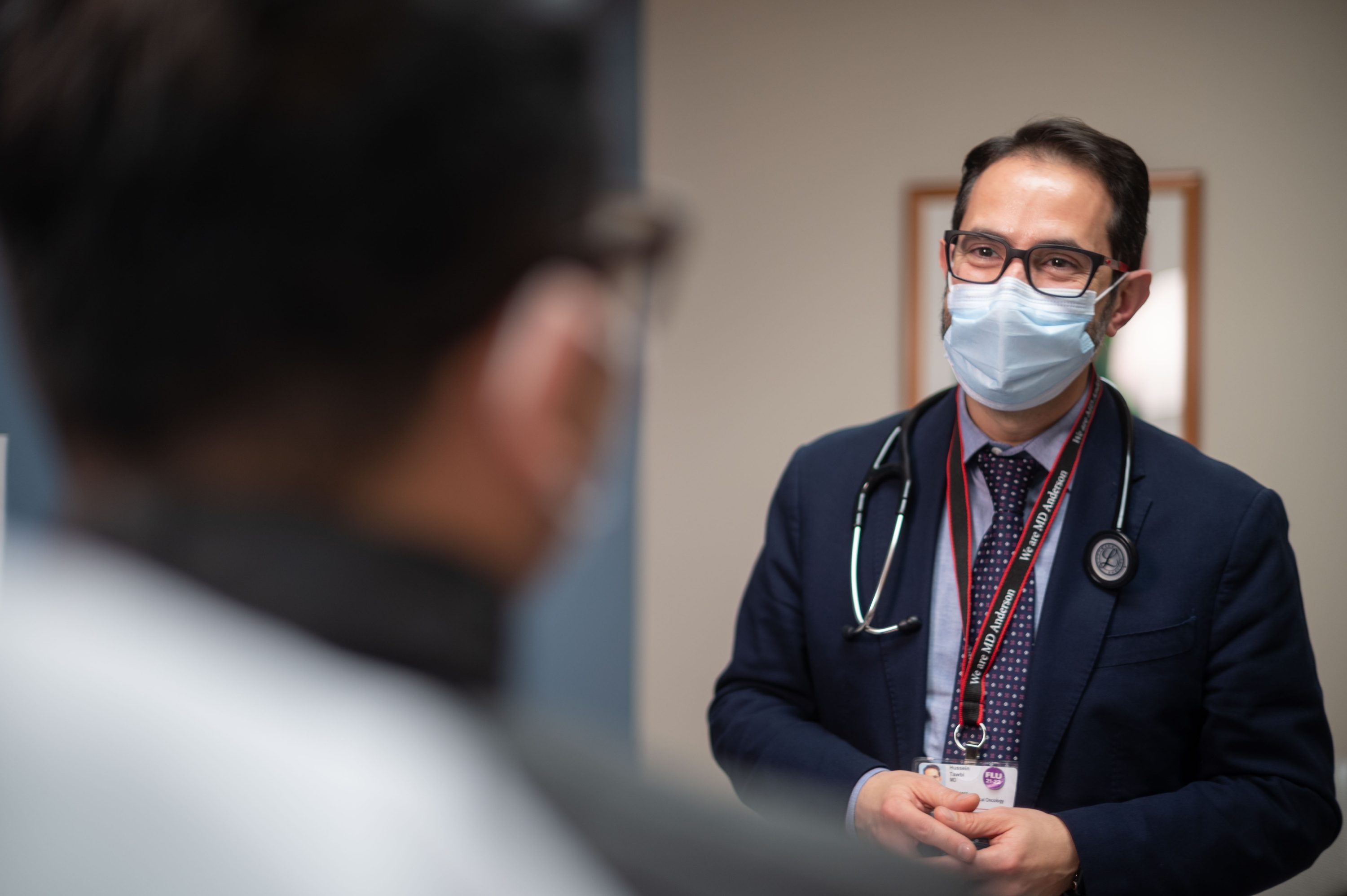 Dr. Hussein Tawbi speaks with a patient in the clinic.