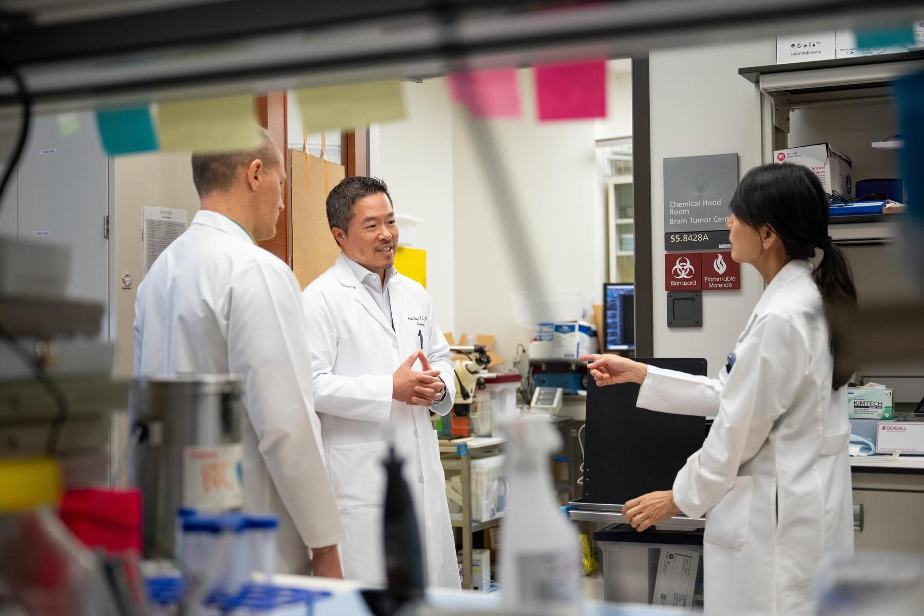 Dr. Chris Young speaks with his colleagues in the lab