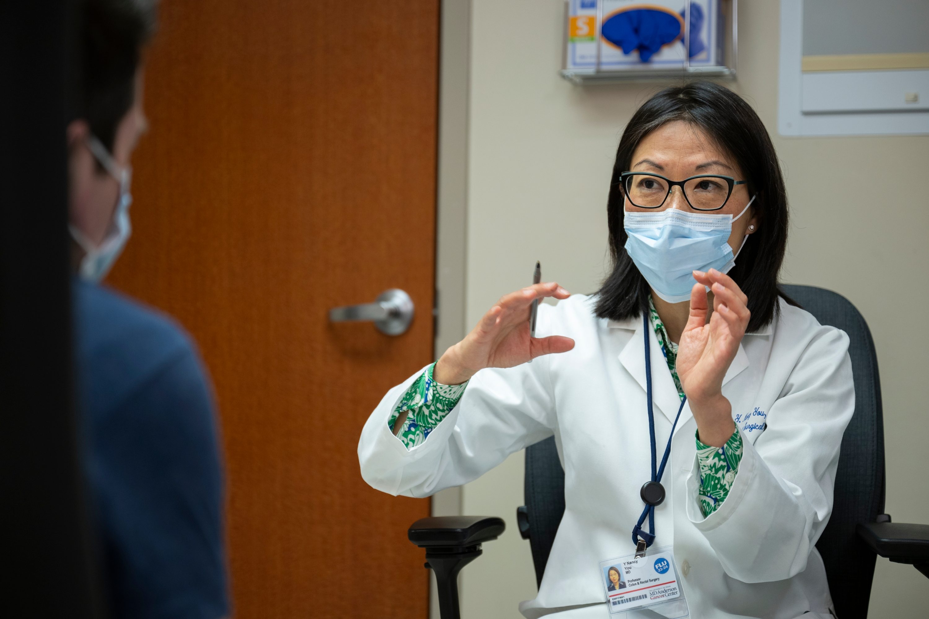 Nancy You, M.D., talking to a young colorectal cancer patient