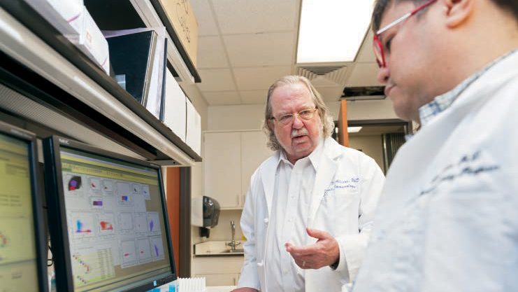 James P. Allison, Ph.D., in a laboratory with a researcher