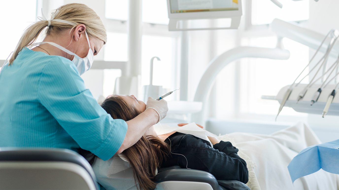 masked dentist working on a patient