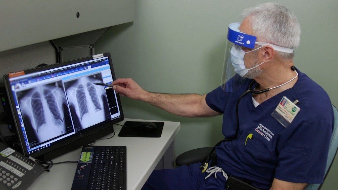 Man views lung imaging on computer screens