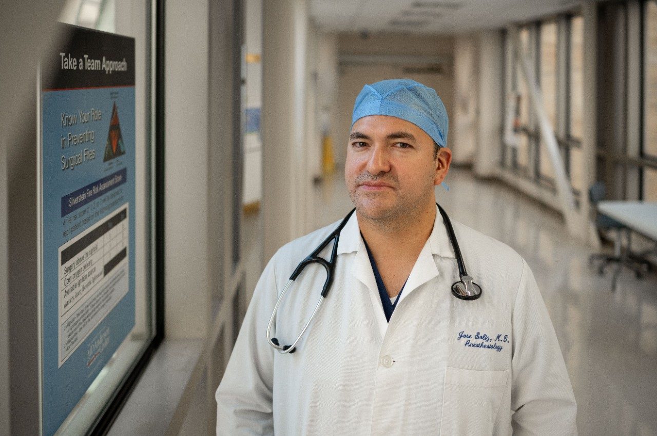 Jose Soliz, M.D., stands in a hallway looking at the camera
