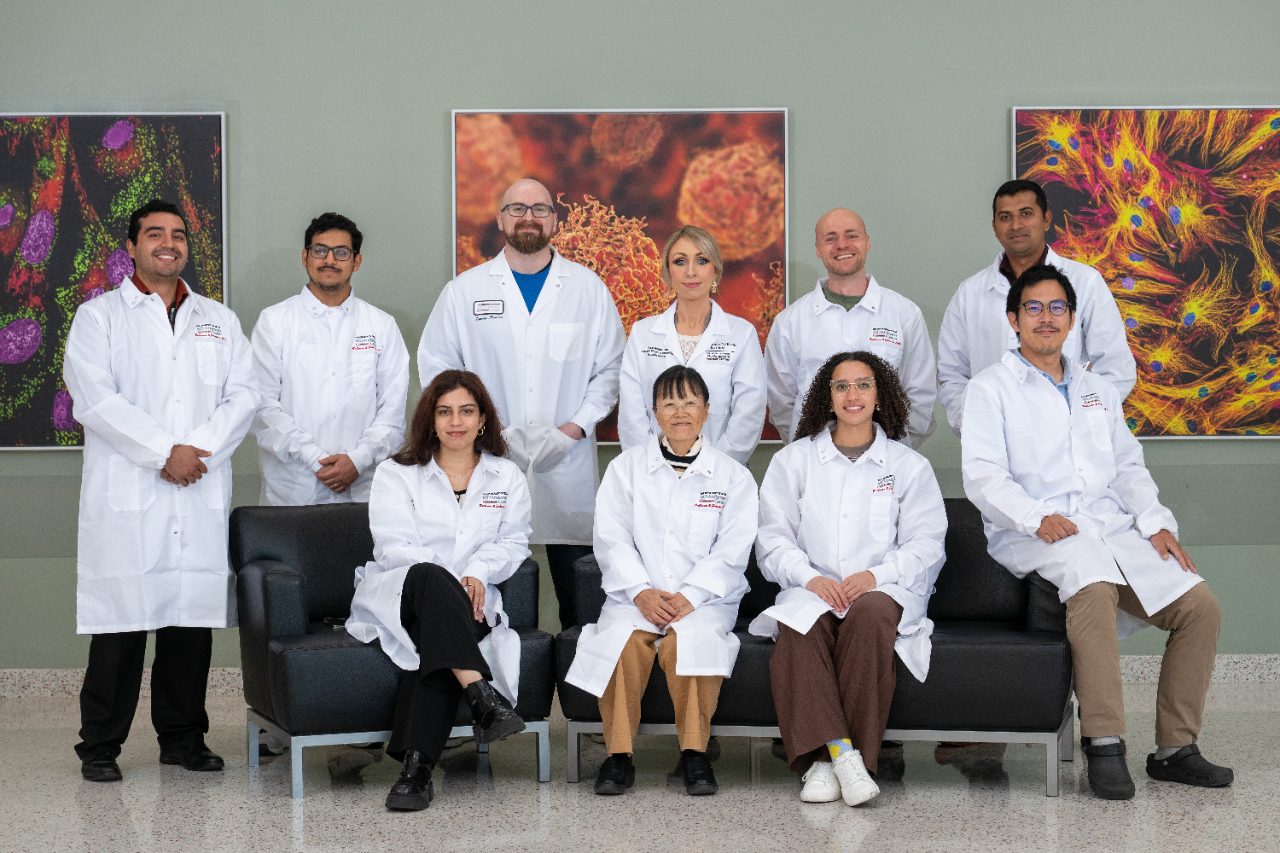 Group photo of lab members wearing white coats